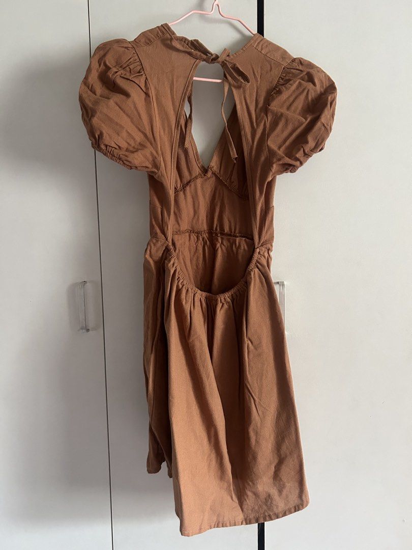 Candy Brown Puff Sleeve Open Back Dress (Category: Dresses) located in Quezon City. Submitted by emayeah (Listing ID 1466574769, Image 2). Description: - Style: Brown puff sleeve dress with a deep V-neck and open back - Fit: Fitted waist with a flared mini skirt - Details: Tied closure at the back neck - Condition: Brand new with original store tags still attached, never worn - Size: Medium.
