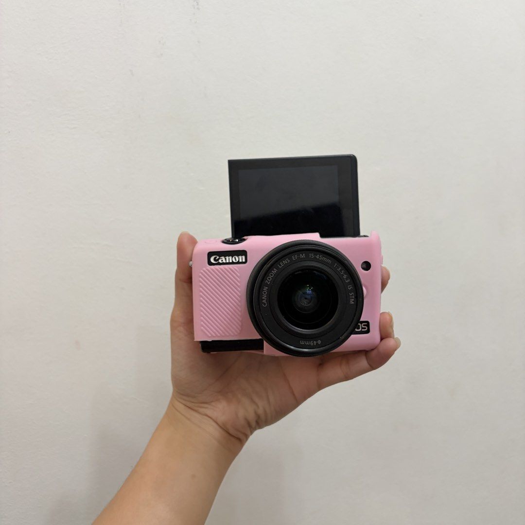 Canon EOS M100 Mirrorless Camera with Pink Case and Accessories (Category: Cameras) located in Valenzuela. Submitted by crisalyz (Listing ID 1466756326, Image 1). Description: IN COLOR BLACK 🖤 (mirrorless camera) ✔️best alternative for Canon G7X Mark Series and Canon SX740HS ㅤᵕ̈ 𖤓 PM ME FOR MORE SAMPLE PICS NO FUNCTIONAL ISSUE! about: - 24.2 MP | full hd video - touchscreen - flipscreen - pop-up flash - red eye flash - wifi transfer (very conve