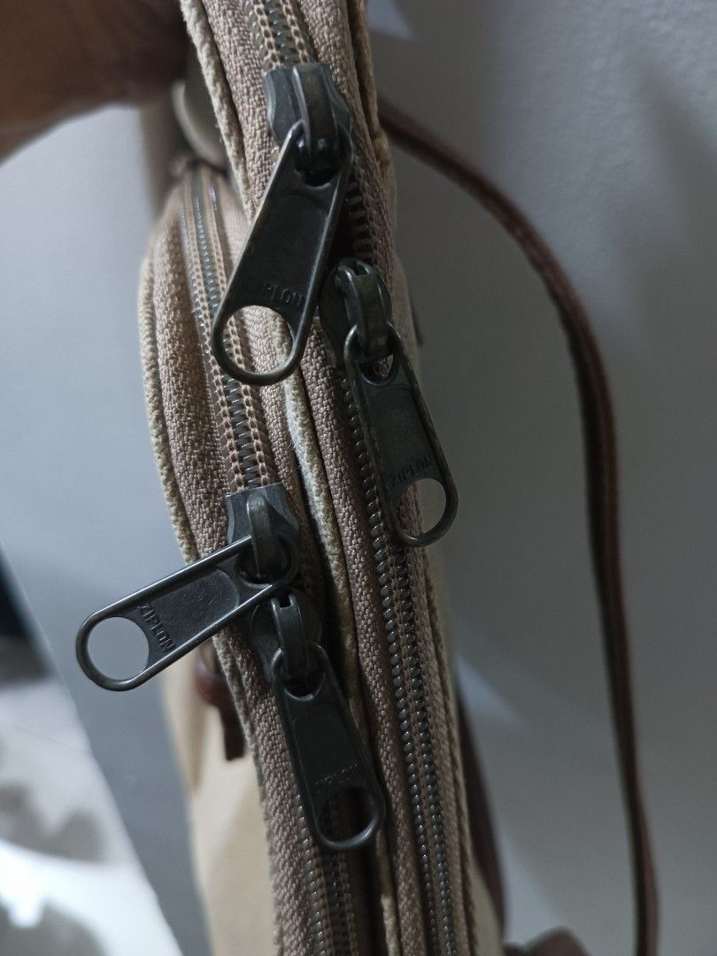 Canvas and brown leatherette mini backpack (Category: Backpacks) located in Quezon City. Submitted by arvietekto (Listing ID 1466577853, Image 3). Description: - Color & Material: Khaki canvas body with brown leatherette trim and straps - Storage: Multiple compartments with secure Ziplon zippers - Exterior: Front flap with buckle accent and a convenient back zippered pocket - Interior: Light cream lining with an extra zip pocket - Condition: Clea