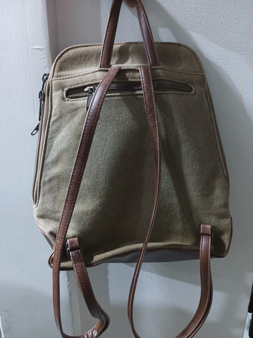 Canvas and brown leatherette mini backpack (Category: Backpacks) located in Quezon City. Submitted by arvietekto (Listing ID 1466577853, Image 2). Description: - Color & Material: Khaki canvas body with brown leatherette trim and straps - Storage: Multiple compartments with secure Ziplon zippers - Exterior: Front flap with buckle accent and a convenient back zippered pocket - Interior: Light cream lining with an extra zip pocket - Condition: Clea