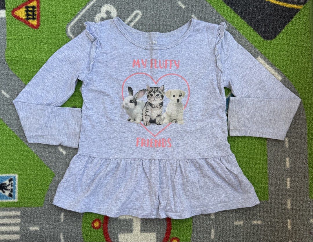 Carter's Long Sleeve Blouse Shirt (Category: Babies & Kids Fashion) located in Rizal. Submitted by preloovved (Listing ID 1466677271, Image 1). Description: Preloved, 4yo, Super cute Carter's long sleeve top in grey featuring an adorable "My Fluffy Friends" graphic, ruffle shoulders, and a flounce hem. Made from a soft cotton blend, perfect for everyday wear. Carter’s long-sleeved top with “My Fluffy Friends” graphic. Gray color, ruffle shoulders