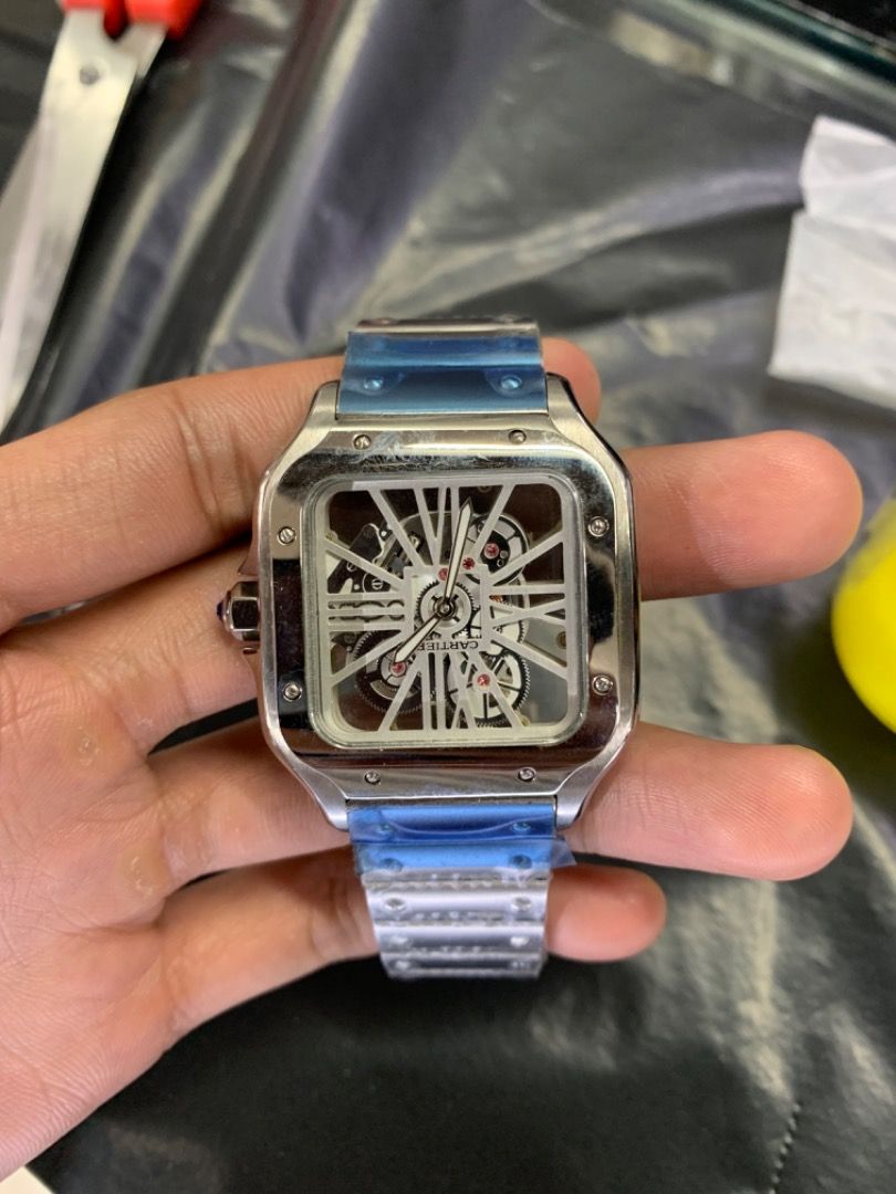 Cartier Skeleton Watch (Category: Luxury Watches) located in Caloocan City. Submitted by mrbigdreams (Listing ID 1466571888, Image 3). Description: - Condition: Brand new and unworn with factory protective plastic still on the bracelet and clasp - Design: Silver-tone square case with a stunning exposed mechanical movement dial - Details: Classic white Roman numeral indexes and a signature blue cabochon crown - Packaging: Comes complete with the i