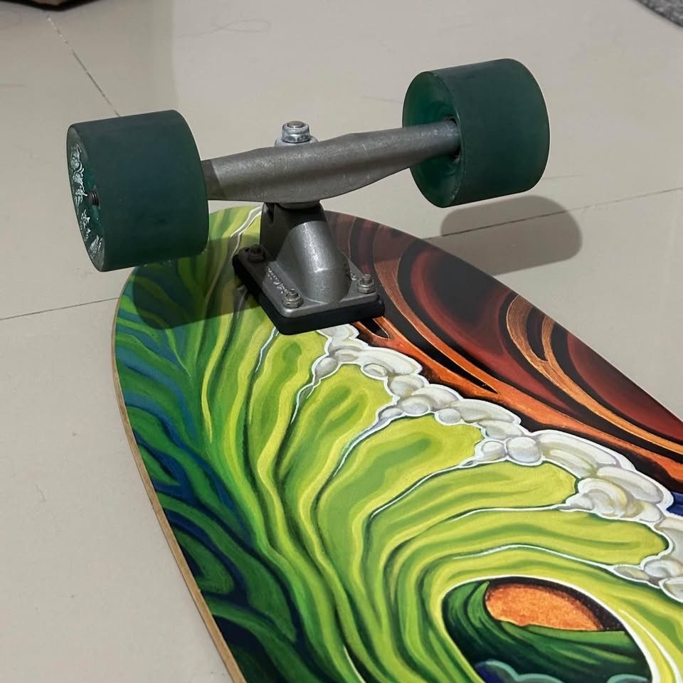 Carver - Greenroom CX 33.75” Surfskate (Category: Skates, Rollerblades & Scooters) located in Consolacion. Submitted by shielaortiz (Listing ID 1466689257, Image 3). Description: - Brand: Carver - Model: Greenroom CX - Size: 33.75 inches - Design: Vibrant wave artwork on the bottom deck with black grip tape on top - Setup: Equipped with responsive Carver trucks and smooth green wheels - Condition: Excellent pre-owned condition with very minimal w
