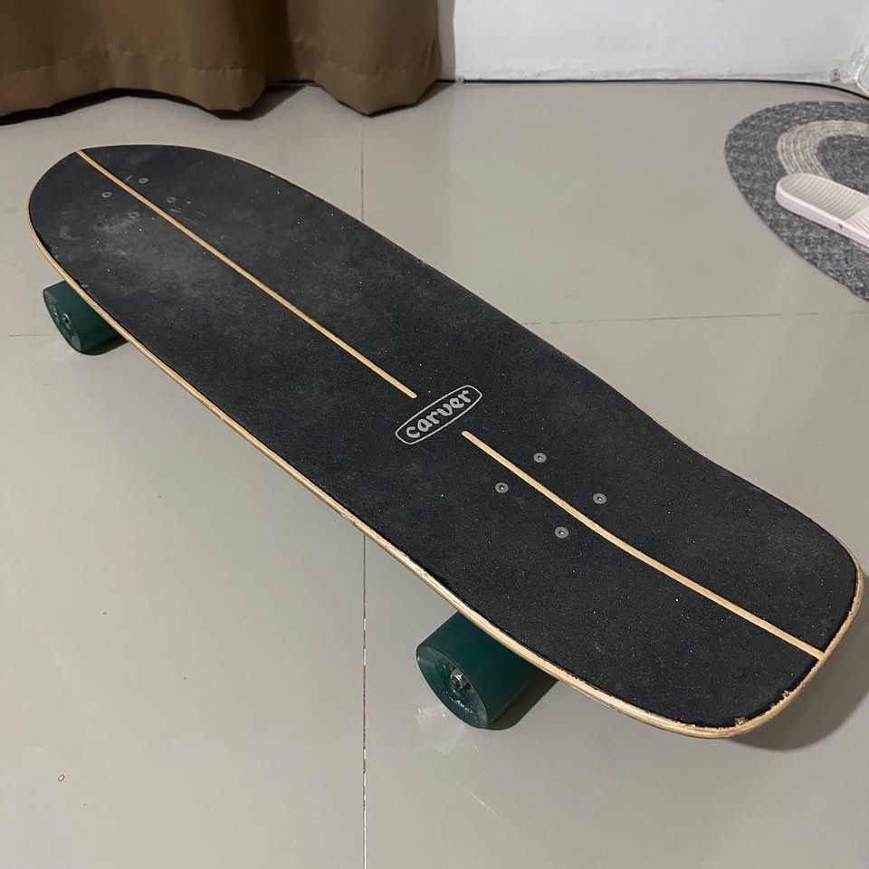 Carver - Greenroom CX 33.75” Surfskate (Category: Skates, Rollerblades & Scooters) located in Consolacion. Submitted by shielaortiz (Listing ID 1466689257, Image 2). Description: - Brand: Carver - Model: Greenroom CX - Size: 33.75 inches - Design: Vibrant wave artwork on the bottom deck with black grip tape on top - Setup: Equipped with responsive Carver trucks and smooth green wheels - Condition: Excellent pre-owned condition with very minimal w