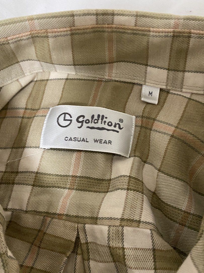 Casual Wear Plaid Button-Down Shirt Size M (Category: Tshirts & Polo Shirts ) located in Manila. Submitted by eileenmaye67636 (Listing ID 1466698015, Image 2). Description: PRELOVED! unisex - Brand/Item: Goldlion Casual Wear Plaid Button-Down Shirt - Size: Medium (tag on collar) - Color/Pattern: Earthy tones with green, cream, and faint orange plaid - Details: Classic collar, button front, single chest pocket, long sleeves shipping: j&t and lalam
