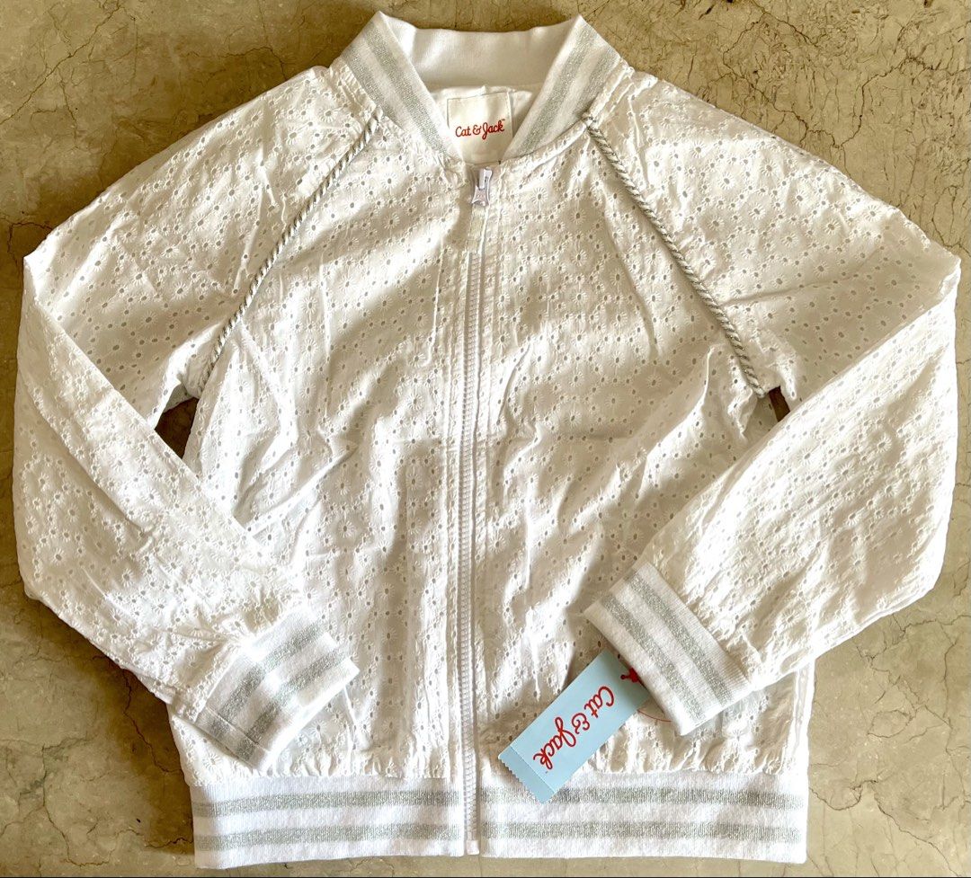 Cat & Jack White Eyelet Bomber Jacket (Category: Babies & Kids Fashion) located in San Juan City. Submitted by rike_ramirez (Listing ID 1466600562, Image 1). Description: Original and authentic, purchased in the USA Brand: Cat & Jack - Size: M (Ages 7/8) - Color: Fresh white with silver accents - Design: All-over eyelet embroidery with silver metallic ribbed collar, cuffs, and hem - Details: Chic silver piping along raglan sleeves and full front 