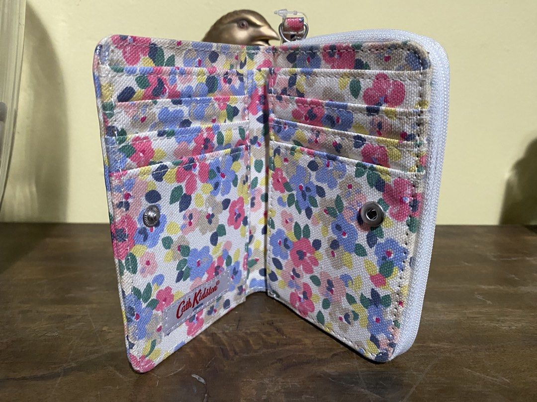 Cath Kidston Floral Zip Around Wallet (Category: Wallets & Card holders) located in Baguio. Submitted by SweetRepeat (Listing ID 1466572114, Image 3). Description: - Brand new with original store tags attached - Authentic Cath Kidston design featuring a white background with vibrant floral print - Secure snap button main closure and all-around white zip closure - Multiple card slots to keep your cards organized - Convenient zippered coin compartm