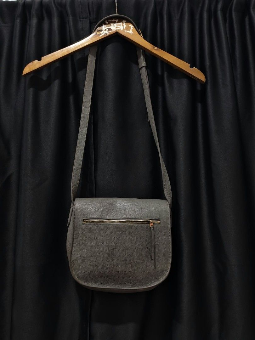 Celine Grey Leather Crossbody Bag (Category: Luxury Bags & Wallets) located in Baguio. Submitted by solo_ukay (Listing ID 1463808514, Image 2). Description: - Authentic Celine grey leather crossbody bag - Features a front zip pocket - Secure flap closure with a gold buckle - Adjustable strap for comfortable wear - Classic, minimalist design perfect for everyday use - Shows minor signs of wear on the hardware.