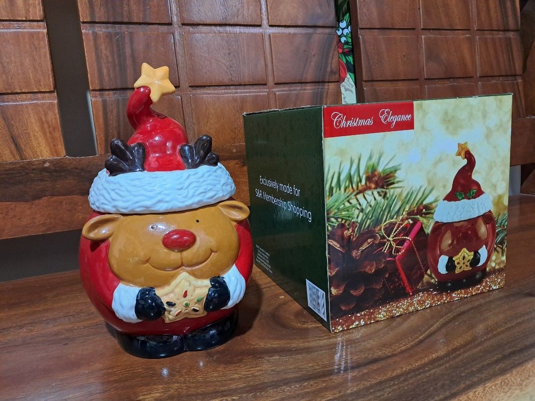 Christmas Elegance Reindeer Ceramic Cookie Jar with Box (Category: Food Organization & Storage) located in Makati City. Submitted by Titan (Listing ID 1466631074, Image 1). Description: - Adorable ceramic reindeer cookie jar wearing a festive Santa hat - Holds holiday cookies, treats, and candies - Measures approx. 11 inches tall from base to star tip - Features hand-painted details including a red nose, black mittens, and a star cookie - Comes w