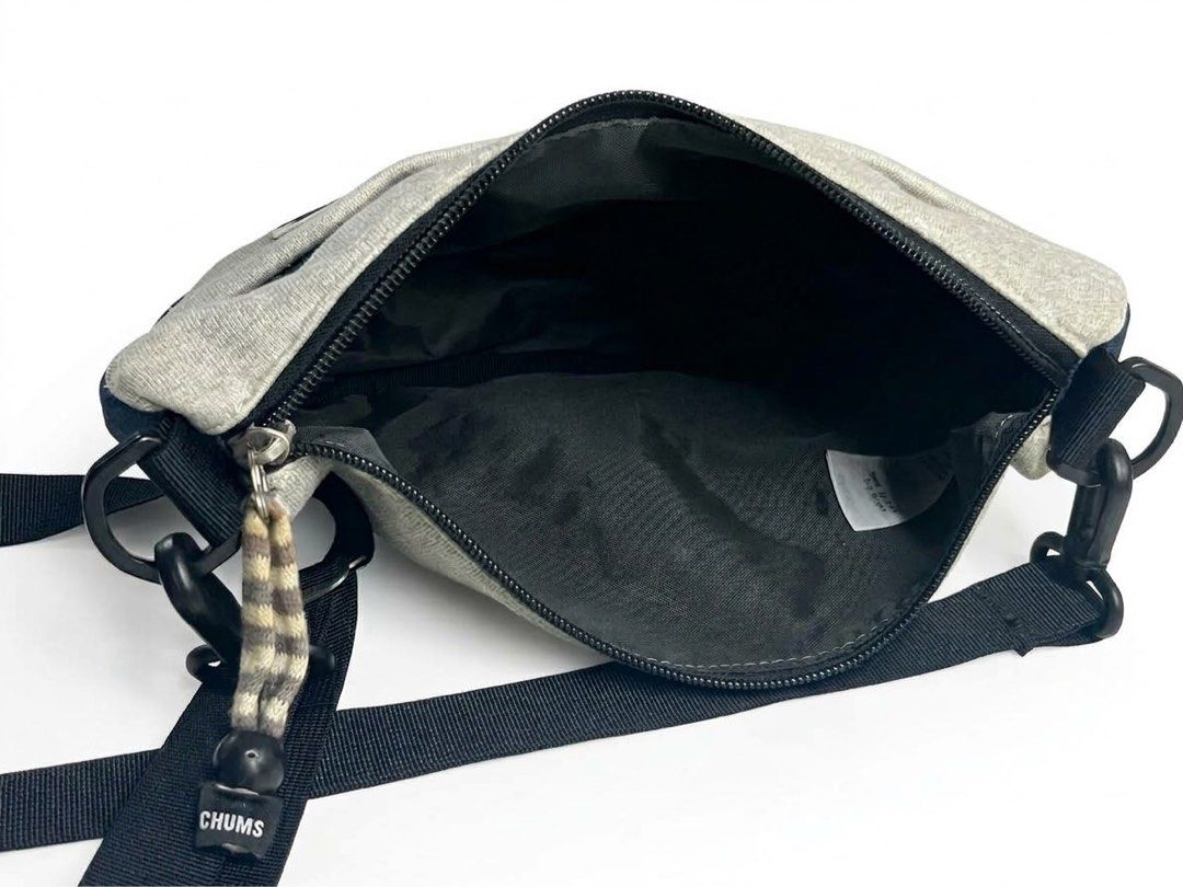 Chums Sweat & Nylon Sling Bag - Heather Gray (Category: Sling Bags) located in Manila. Submitted by djmac12271982 (Listing ID 1466711931, Image 3). Description: Design & Storage: Features a main zippered compartment with a black lining, an interior care/tag pocket, and a front pocket with velcro closure for quick-access essentials. Straps & Hardware: Adjustable black webbing cross-body strap with sturdy clip attachments and heavy-duty zippers. Co