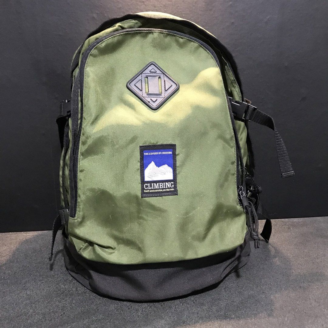 CLIMBING Green Backpack with Black Base and Straps (Category: Backpacks) located in Baao. Submitted by all.things.japan (Listing ID 1466713547, Image 2). Description: 16.0 x 8.0 x 12.0 inches -Color: Green canvas with a black reinforced base - Comfort: Padded shoulder straps and adjustable sternum strap - Storage: Front pocket with a diamond lash tab for extra gear - Stability: Side compression straps with secure plastic buckles - Design: Feature