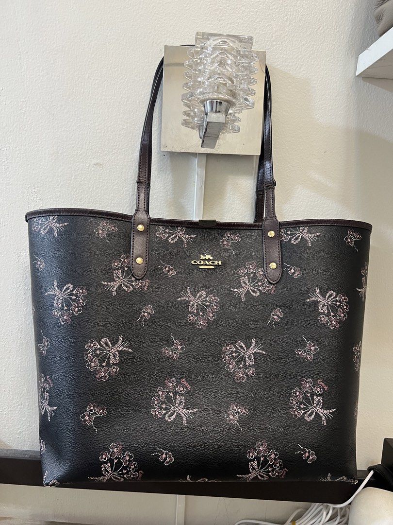 Coach Bow Print Reversible Tote Bag (Category: Tote Bags) located in Manila. Submitted by 2s2knpt9nw34311 (Listing ID 1466649431, Image 1). Description: - Brand: Coach - Color: Dark brown with all-over floral and pink bow graphic print - Hardware: Gold-tone - Straps: Double shoulder straps - Interior: Roomy open-top design with classic Coach story patch - Condition: Great size for daily commute, school, or errands - Guaranteed authentic and well-