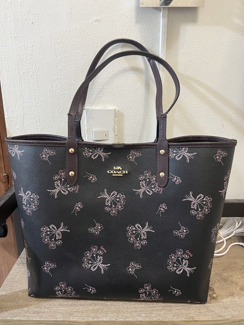 Coach Bow Print Reversible Tote Bag (Category: Tote Bags) located in Manila. Submitted by 2s2knpt9nw34311 (Listing ID 1466649431, Image 2). Description: - Brand: Coach - Color: Dark brown with all-over floral and pink bow graphic print - Hardware: Gold-tone - Straps: Double shoulder straps - Interior: Roomy open-top design with classic Coach story patch - Condition: Great size for daily commute, school, or errands - Guaranteed authentic and well-