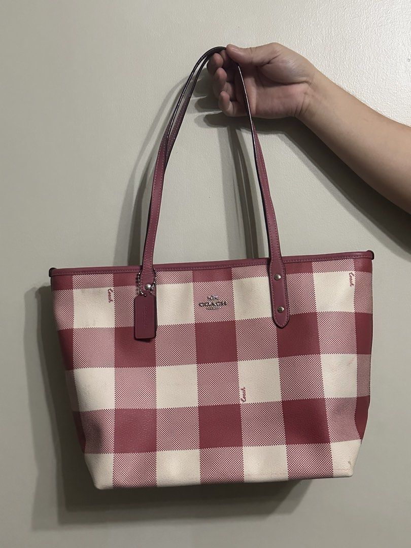 Coach Red Gingham Print Tote Bag (Category: Tote Bags) located in Bulacan. Submitted by savifinds (Listing ID 1466596864, Image 1). Description: - Authentic Coach tote bag in a cute red and white gingham print - Comfortable dark pink leather shoulder straps - Sleek silver-tone hardware with a matching hanging leather tag - Roomy open-top design, perfect for your daily essentials - Features subtle Coach script text throughout the pattern - Conditi