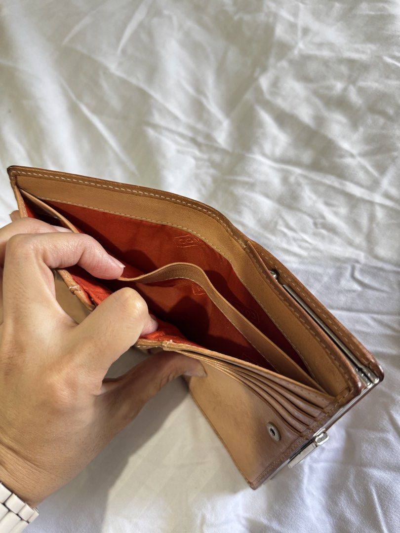 Coach Signature C Brown Leather Wallet (Category: Wallets & Card holders) located in Pasig City. Submitted by marizanne04 (Listing ID 1466727008, Image 3). Description: - Authentic Coach wallet in classic brown signature canvas with tan leather trim - Secure snap button closure for card slots and cash compartments - Separate kiss-lock coin pocket with vibrant orange fabric lining - Compact size that fits easily into any handbag - Shows normal sig