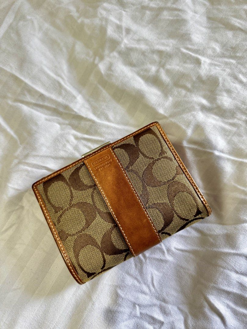 Coach Signature C Brown Leather Wallet (Category: Wallets & Card holders) located in Pasig City. Submitted by marizanne04 (Listing ID 1466727008, Image 1). Description: - Authentic Coach wallet in classic brown signature canvas with tan leather trim - Secure snap button closure for card slots and cash compartments - Separate kiss-lock coin pocket with vibrant orange fabric lining - Compact size that fits easily into any handbag - Shows normal sig