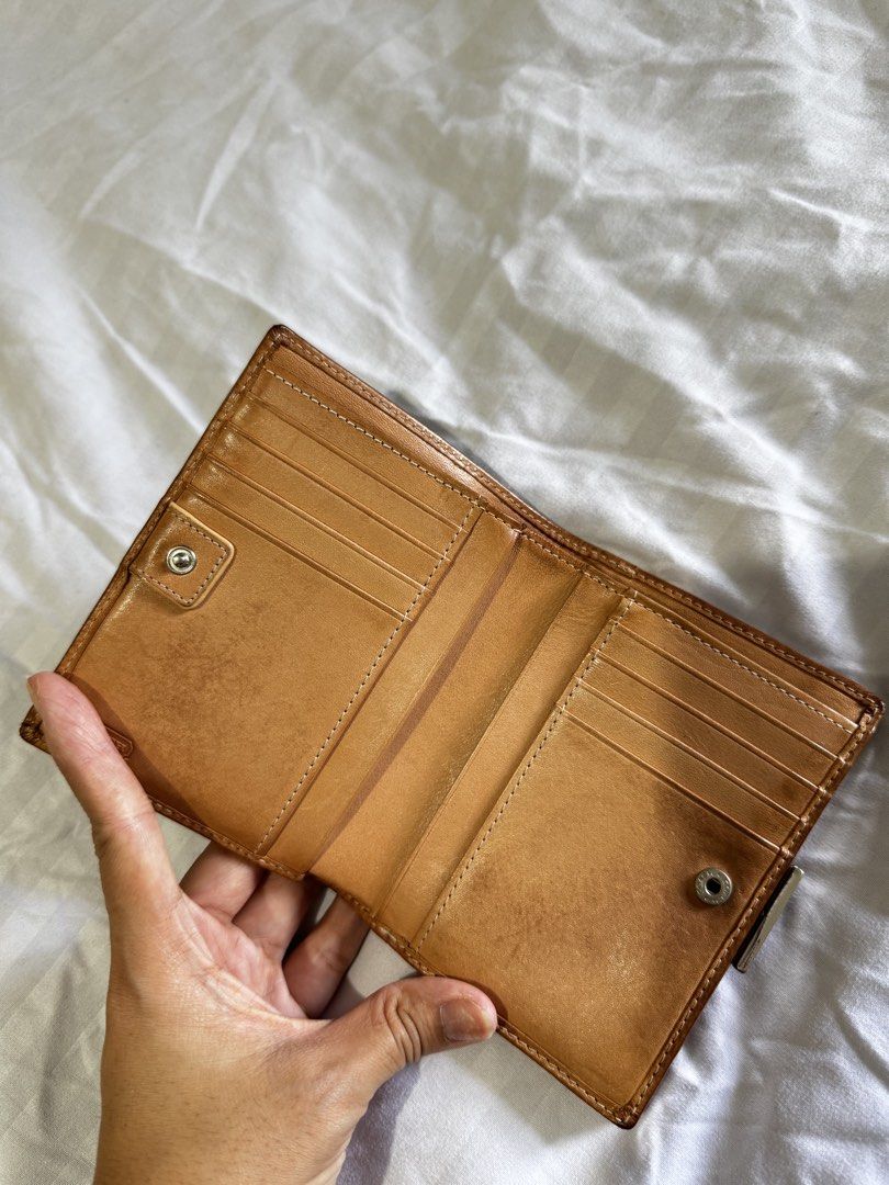 Coach Signature C Brown Leather Wallet (Category: Wallets & Card holders) located in Pasig City. Submitted by marizanne04 (Listing ID 1466727008, Image 2). Description: - Authentic Coach wallet in classic brown signature canvas with tan leather trim - Secure snap button closure for card slots and cash compartments - Separate kiss-lock coin pocket with vibrant orange fabric lining - Compact size that fits easily into any handbag - Shows normal sig
