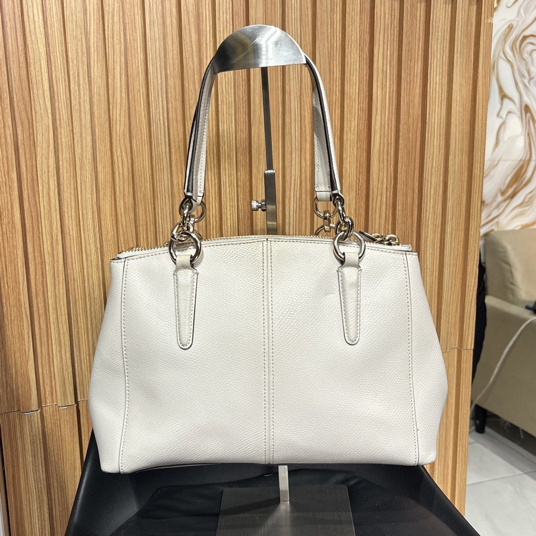 Coach White Leather Tote Handbag (Category: Luxury Bags & Wallets) located in Bambang. Submitted by heats777 (Listing ID 1466664124, Image 2). Description: - Brand: Coach - Color: White with premium gold-tone hardware - Compartments: Double top zip closures with a secure middle magnetic snap section - Interior: Fabric-lined with handy slip pockets - Handles: Dual leather carry handles for comfortable use - Extras: Includes a matching hanging leat
