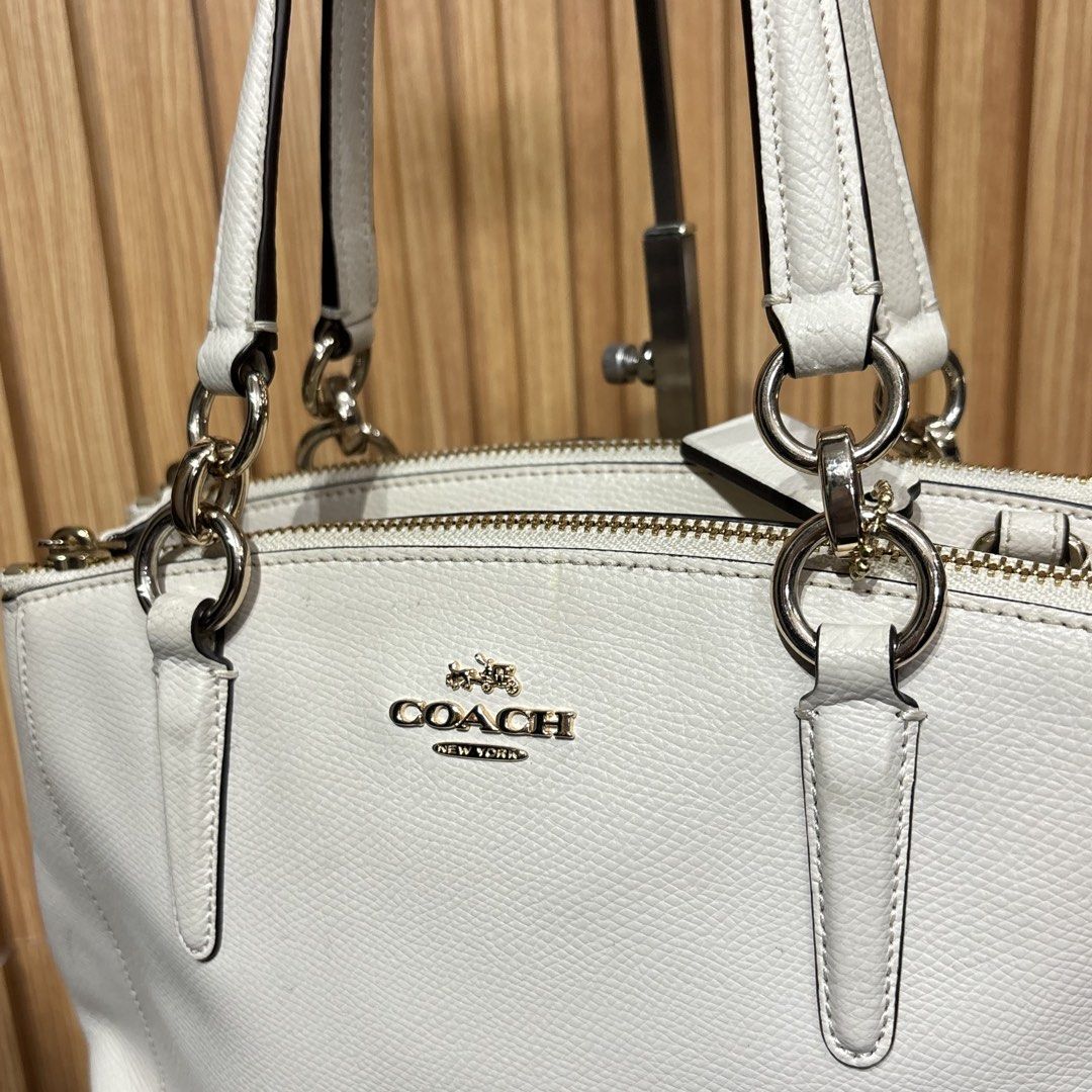 Coach White Leather Tote Handbag (Category: Luxury Bags & Wallets) located in Bambang. Submitted by heats777 (Listing ID 1466664124, Image 3). Description: - Brand: Coach - Color: White with premium gold-tone hardware - Compartments: Double top zip closures with a secure middle magnetic snap section - Interior: Fabric-lined with handy slip pockets - Handles: Dual leather carry handles for comfortable use - Extras: Includes a matching hanging leat