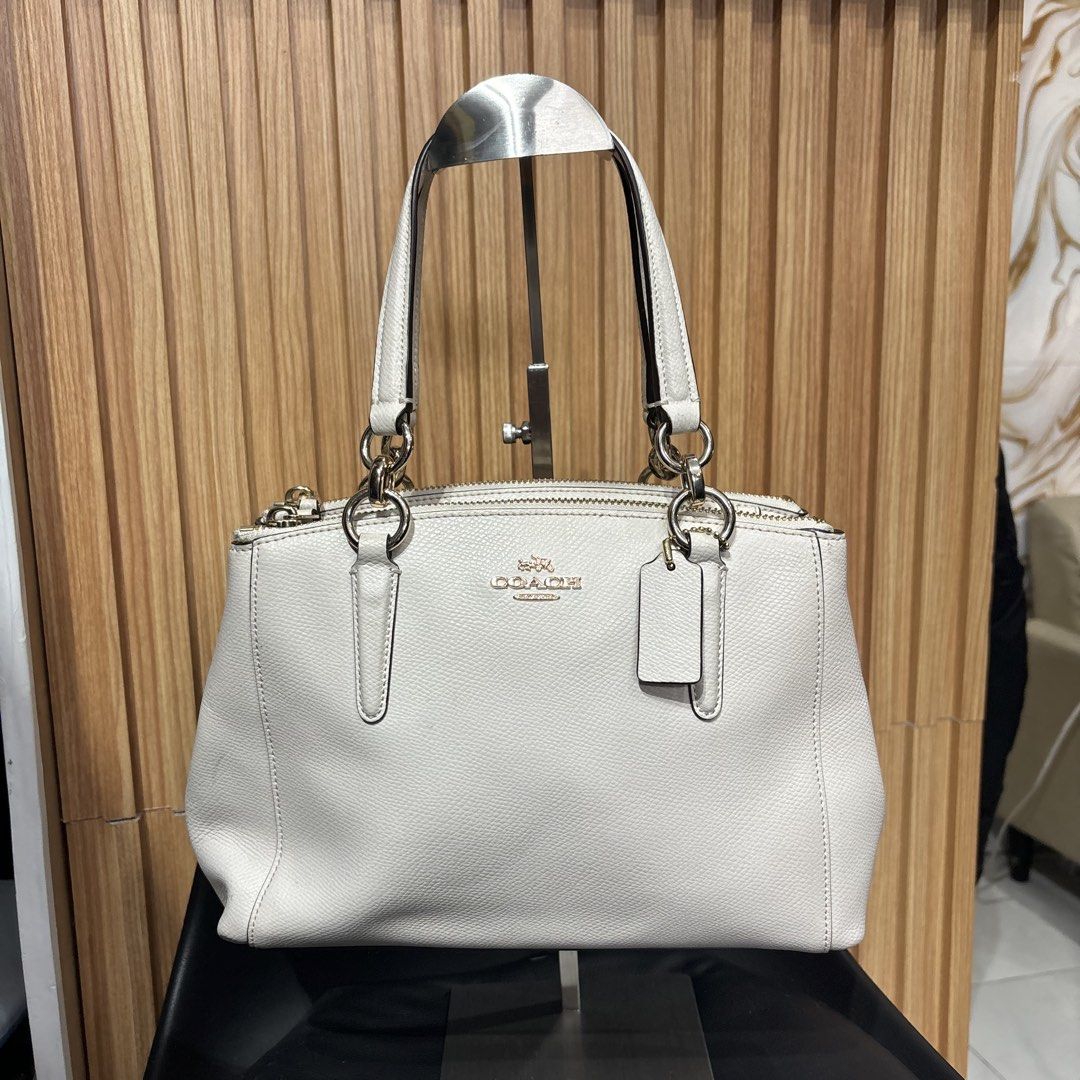 Coach White Leather Tote Handbag (Category: Luxury Bags & Wallets) located in Bambang. Submitted by heats777 (Listing ID 1466664124, Image 1). Description: - Brand: Coach - Color: White with premium gold-tone hardware - Compartments: Double top zip closures with a secure middle magnetic snap section - Interior: Fabric-lined with handy slip pockets - Handles: Dual leather carry handles for comfortable use - Extras: Includes a matching hanging leat