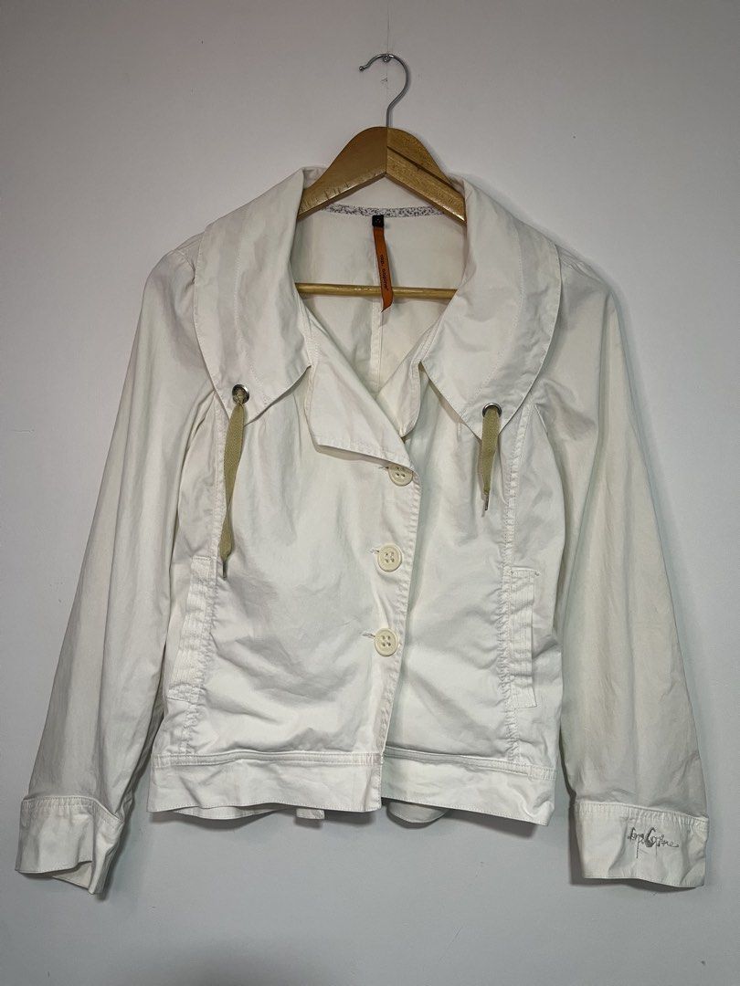 Cop. Copine Frida White Veste Jacket (Category: Coats, Jackets and Outerwear) located in Dasmarinas. Submitted by thriftedbygii (Listing ID 1466714050, Image 1). Description: - Brand: Cop. Copine (Model: Frida Veste) - Color: White - Closure: Button-down front with three large buttons - Collar: Asymmetric design with decorative drawstring cords and metal eyelets - Sleeves: Long sleeves featuring embroidered branding on the left cuff - Back Detail