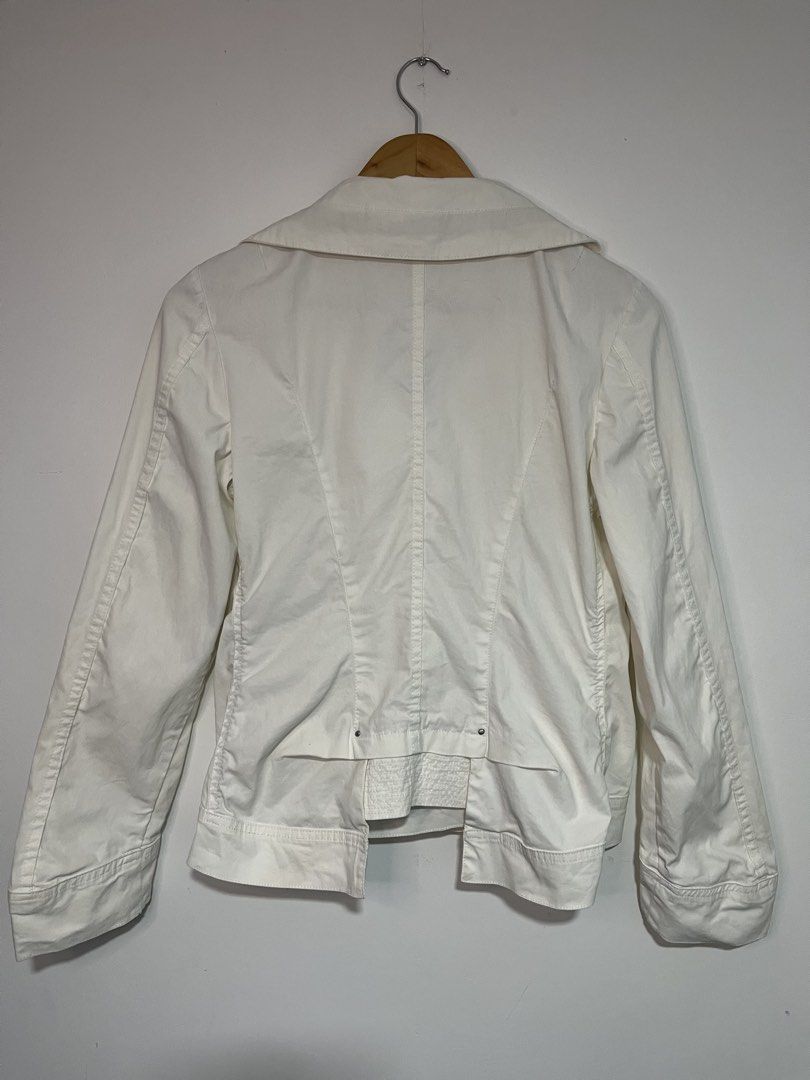 Cop. Copine Frida White Veste Jacket (Category: Coats, Jackets and Outerwear) located in Dasmarinas. Submitted by thriftedbygii (Listing ID 1466714050, Image 3). Description: - Brand: Cop. Copine (Model: Frida Veste) - Color: White - Closure: Button-down front with three large buttons - Collar: Asymmetric design with decorative drawstring cords and metal eyelets - Sleeves: Long sleeves featuring embroidered branding on the left cuff - Back Detail
