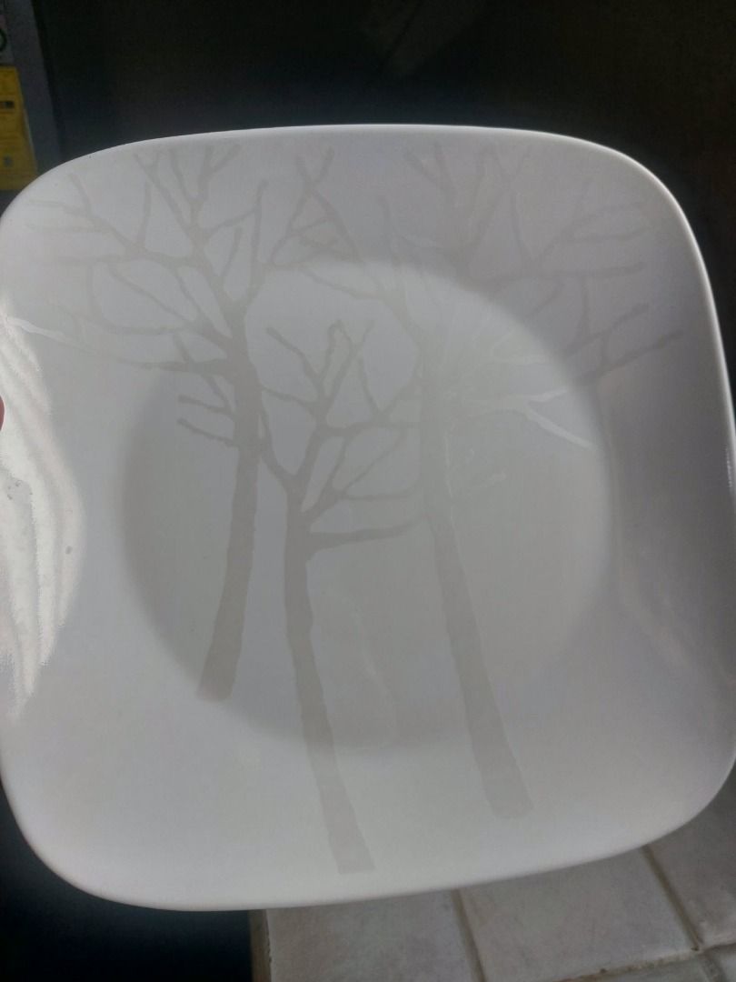 Corelle Square Vitrelle Dinner Plate Tree Silhouette Pattern (Category: Dinnerware & Cutlery) located in Marikina City. Submitted by ikid6121 (Listing ID 1466657457, Image 2). Description: - Authentic Corelle square plate, proudly Made in USA - Crafted from durable, break- and chip-resistant Vitrelle glass - Elegant white background with a modern grey tree and branch silhouette - Clearly visible backstamp guaranteeing authenticity - Microwave and
