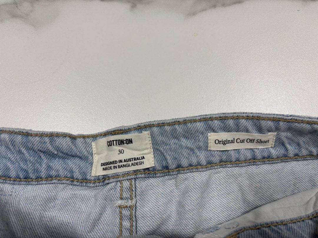 Cotton On Original Cut Off Short Size 30 (Category: Shorts) located in Pasay City. Submitted by altheatheaaeia (Listing ID 1466683193, Image 2). Description: - Brand: Cotton On - Style: Original Cut Off Short with raw frayed hems - Wash: Light wash denim with subtle front distressing - Size: 30 - Fit: Mid-rise with belt loops and button closure - Pockets: Functional front and back pockets - Condition: Great for pairing with casual tees and tanks.