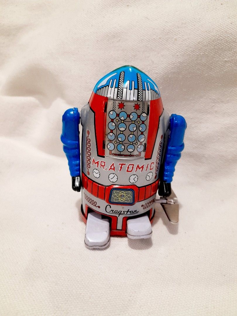 Cragstan Mr. Atomic Tin Toy Robot with Box (Category: Vintage Collectibles) located in Quezon City. Submitted by warmgem.dde5c0 (Listing ID 1466606434, Image 1). Description: - Vintage Cragstan Mr. Atomic wind-up tin toy robot - Classic blue and red design with clockwork chest graphics - Compact size measuring approximately 3.5 inches tall - Fully working wind-up mechanism with attached key - Comes with the original matching graphic box featuring