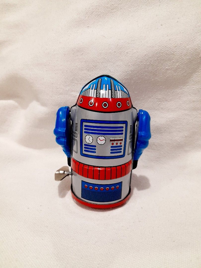 Cragstan Mr. Atomic Tin Toy Robot with Box (Category: Vintage Collectibles) located in Quezon City. Submitted by warmgem.dde5c0 (Listing ID 1466606434, Image 2). Description: - Vintage Cragstan Mr. Atomic wind-up tin toy robot - Classic blue and red design with clockwork chest graphics - Compact size measuring approximately 3.5 inches tall - Fully working wind-up mechanism with attached key - Comes with the original matching graphic box featuring