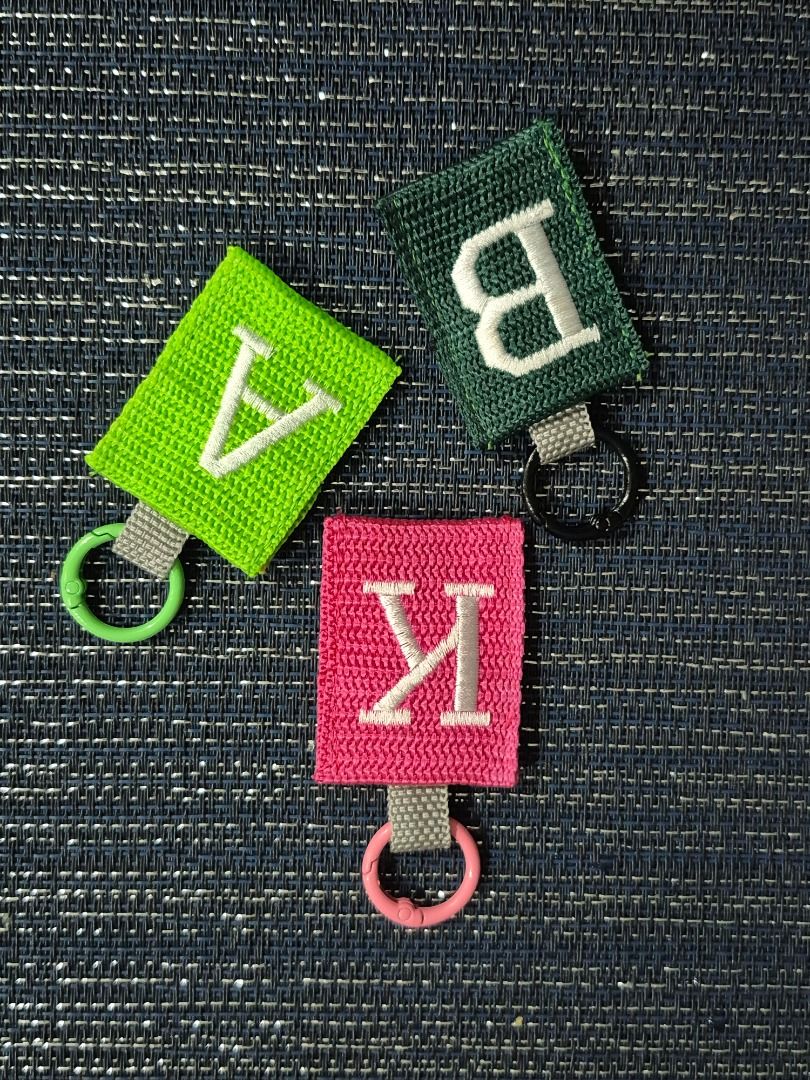 Custom Initial Embroidered Keychain Letters (Category: Handmade Craft) located in Caloocan City. Submitted by keengem.16620b (Listing ID 1466605519, Image 3). Description: - Embroidered Initial keychains - Durable textured with clean stitching - Secure circular spring ring clasp with a grey strap - Versatile accessory for keys, bags, or backpacks - 75 pesos each Marikina area.