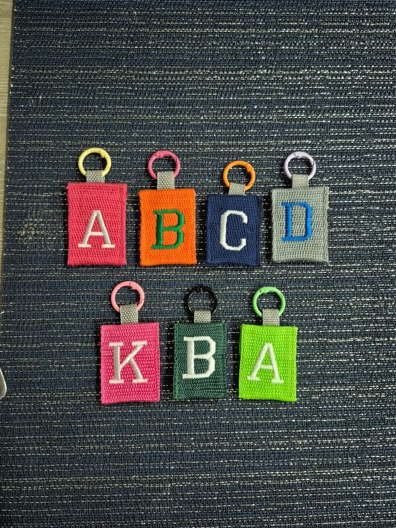 Custom Initial Embroidered Keychain Letters (Category: Handmade Craft) located in Caloocan City. Submitted by keengem.16620b (Listing ID 1466605519, Image 2). Description: - Embroidered Initial keychains - Durable textured with clean stitching - Secure circular spring ring clasp with a grey strap - Versatile accessory for keys, bags, or backpacks - 75 pesos each Marikina area.