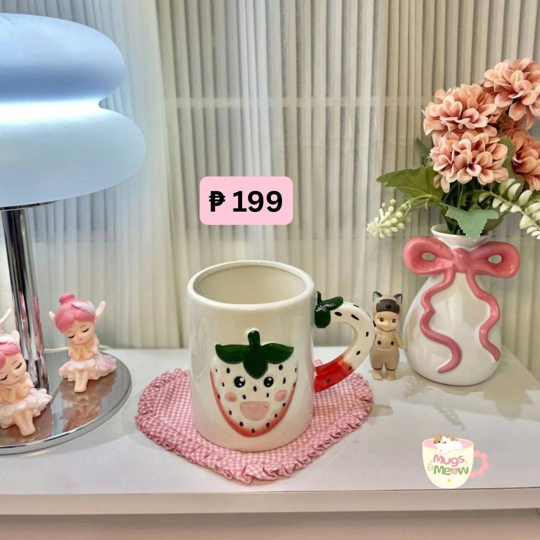 Cute Ceramic Mug with Strawberry Design and Coaster (Category: Coffee & Tea Tableware) located in Quezon City. Submitted by lulufindsph (Listing ID 1466668725, Image 1). Description: - Adorable white ceramic mug with a smiling strawberry design - Includes a matching pink gingham heart-shaped fabric coaster - Standard mug size, perfect for coffee, tea, or hot chocolate - Lovely addition to your desk setup or kitchen - Brand new and ready to ship!.