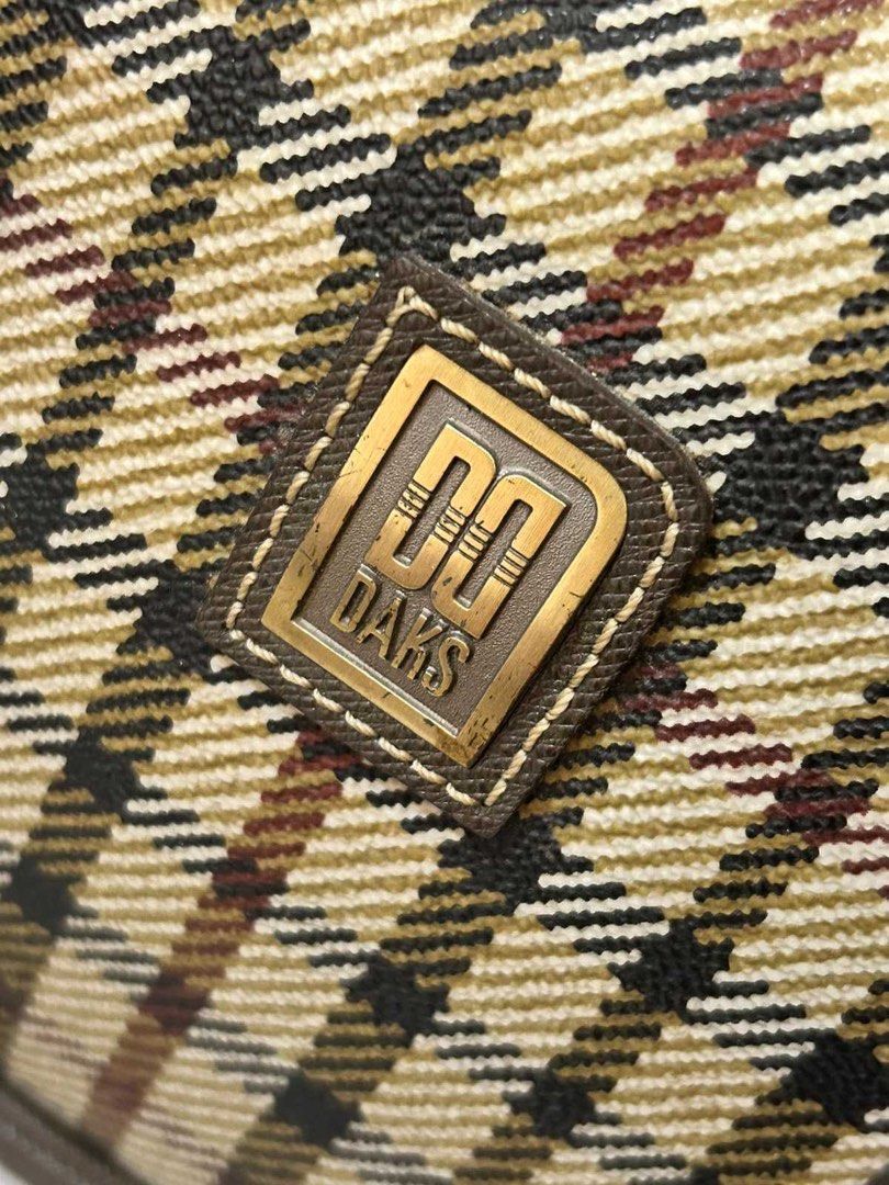 DAKS London Check Pattern Vintage Handbag (Category: Luxury Bags & Wallets) located in Quezon City. Submitted by rosell.xoxo (Listing ID 1466610084, Image 3). Description: - Classic DAKS check pattern with elegant dark brown leather trim - Secure top zip closure with sturdy double top handles - Premium gold-tone hardware featuring the iconic DAKS front logo plate - Spacious interior lined with branded fabric, including a convenient zip pocket - I
