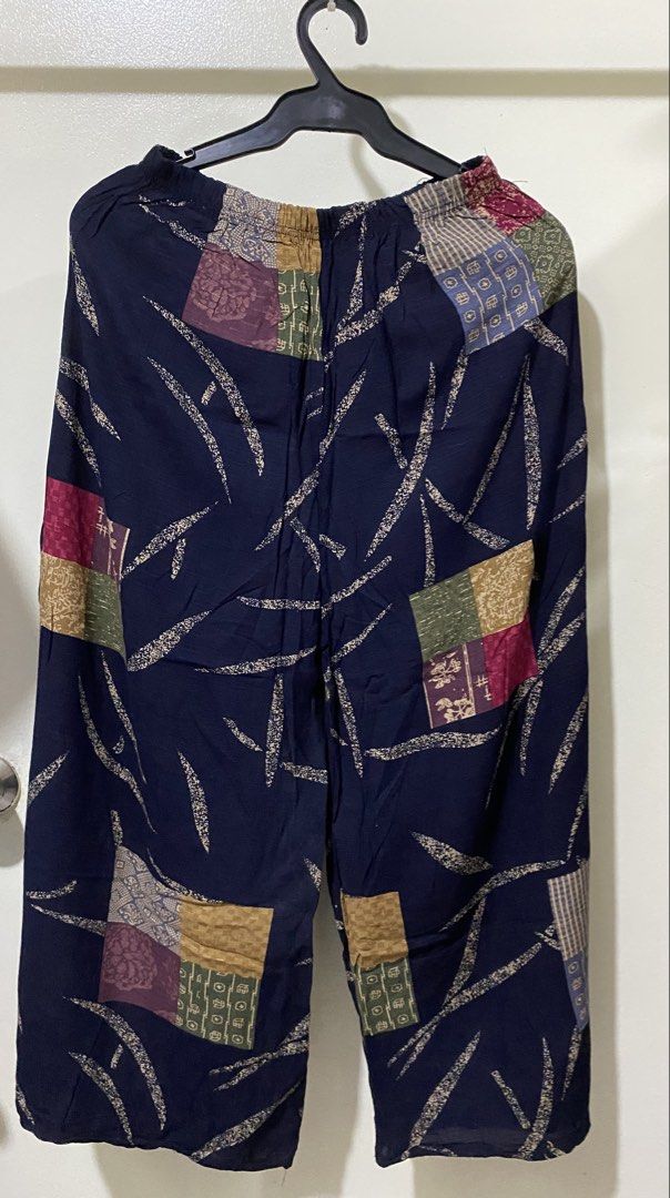 Dark blue patterned loose pants with elastic waist (Category: Jeans) located in Manila. Submitted by divinemercy_29 (Listing ID 1466636931, Image 2). Description: - Color: Dark blue with multicolored patchwork blocks - Fit: Relaxed, loose fit with a comfortable elastic waistband - Design: Unique curved stroke patterns on the waist and lower legs - Condition: Brand new with original tag still attached on the front right side - Perfect for a trendy