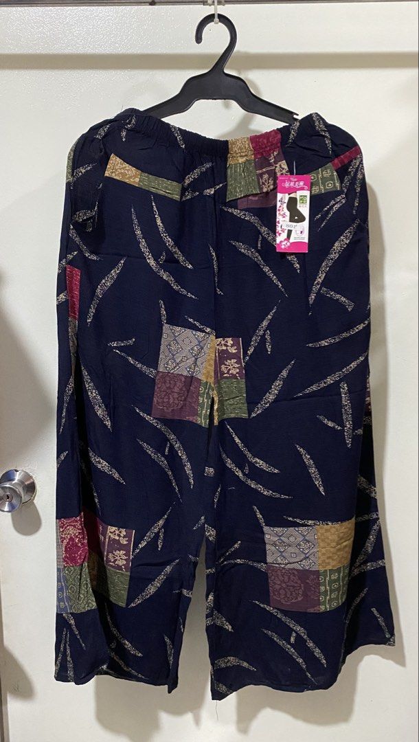Dark blue patterned loose pants with elastic waist (Category: Jeans) located in Manila. Submitted by divinemercy_29 (Listing ID 1466636931, Image 1). Description: - Color: Dark blue with multicolored patchwork blocks - Fit: Relaxed, loose fit with a comfortable elastic waistband - Design: Unique curved stroke patterns on the waist and lower legs - Condition: Brand new with original tag still attached on the front right side - Perfect for a trendy