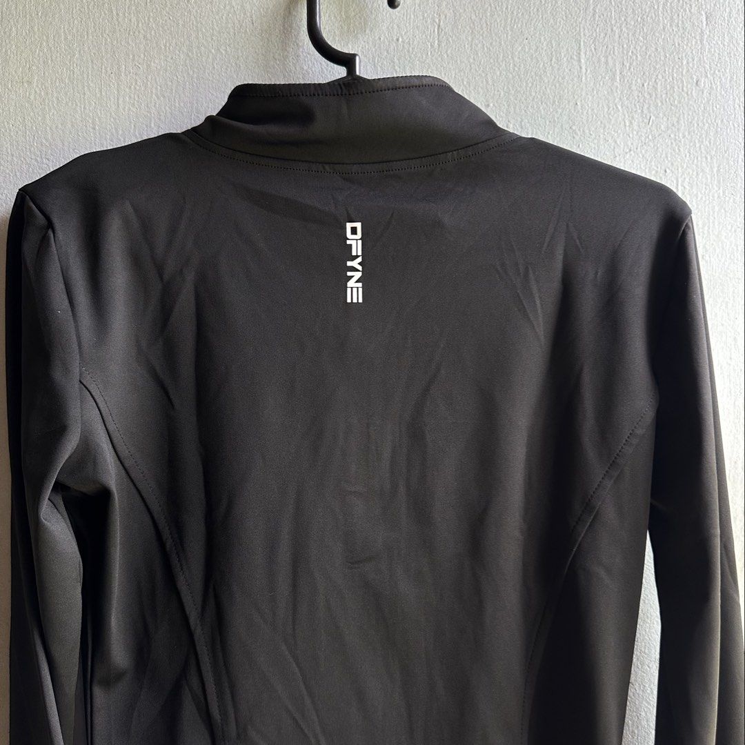 DFYNE Black Athletic Full-Zip Jacket (Category: Coats, Jackets and Outerwear) located in Angeles City. Submitted by alejeong27 (Listing ID 1466571757, Image 3). Description: - Brand: DFYNE - Style: Athletic full-zip jacket with a mock neck and long sleeves - Color: Black with white logo print on the upper left chest and back collar - Fit: Flattering contoured panel seam lines along the front and back - Condition: Brand new in original ziplock pac