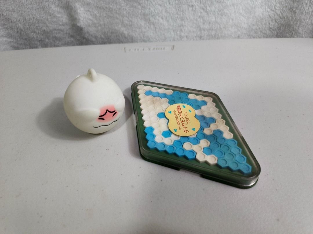 Diamond Puzzle Game and Squishy Toy Bundle (Category: Board Games & Puzzles) located in San Leonardo. Submitted by burgossanleonardo.12345 (Listing ID 1466692918, Image 1). Description: - Bundle Set: Includes a diamond puzzle game and a cute squishy toy - Diamond Puzzle: Blue and white hexagonal pieces in a clear plastic case, great fun brain teaser - Stress Toy: Adorable round white dumpling character with a flushed face and squiggly mouth - Con