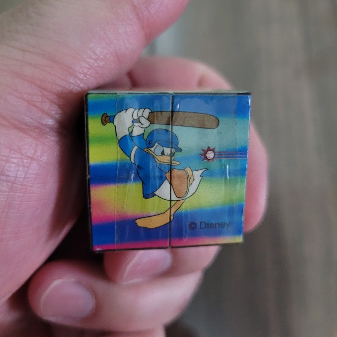 Disney Mickey Mouse Donald Duck baseball puzzle cube (Category: Board Games & Puzzles) located in Pasig City. Submitted by samnok_toys_ph (Listing ID 1466622905, Image 3). Description: - Official Disney licensed mini puzzle cube - Features vibrant Mickey Mouse and Donald Duck baseball artwork on all sides - Compact novelty toy measuring just a few centimeters - Clean surface with crisp, bright printed designs - Includes official holographic Disne