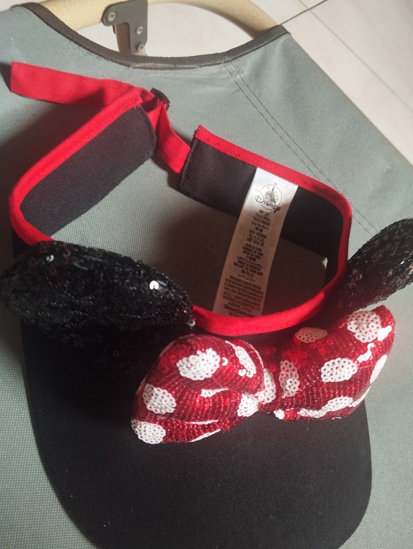 Disney Minnie Mouse Sequin Ears Visor Cap Red Black (Category: Hats & Beanies) located in Manila. Submitted by ljaneee (Listing ID 1466576115, Image 3). Description: - Official Disney Minnie Mouse visor cap - Black brim with sparkly black sequin ears - Iconic red sparkly bow with white polka dots - Adjustable strap at the back with red trim for a custom fit - One size fits most - Brand new with official tag attached.