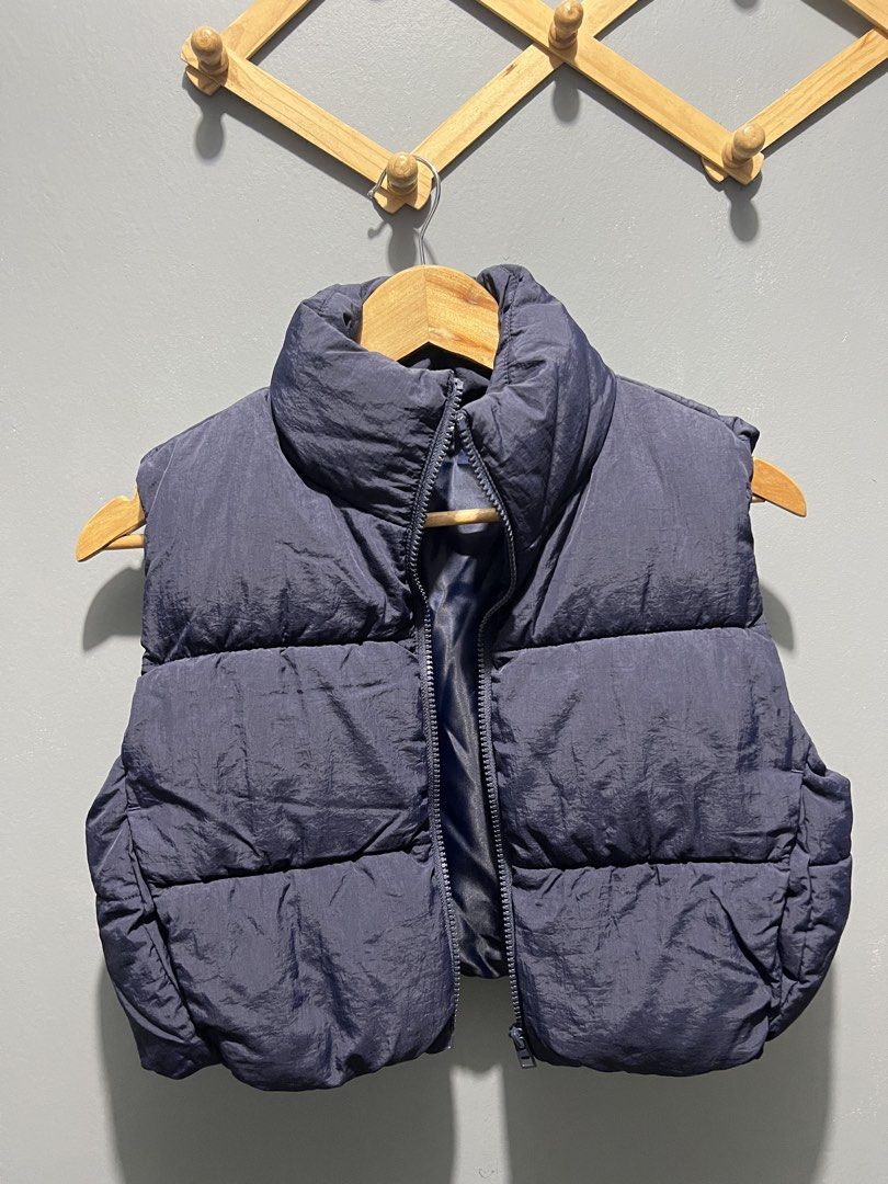 DIVIDED Navy Puffer Vest Size XS (Category: Sleeveless) located in Manila. Submitted by bosetph (Listing ID 1466570790, Image 1). Description: - Brand: DIVIDED - Size: XS - Color: Navy blue - Design: Quilted with synthetic padding and high stand collar - Closure: Full front zipper - Condition: Clean, no obvious flaws - Perfect for layering with hoodies, sweaters, or long-sleeve shirts.