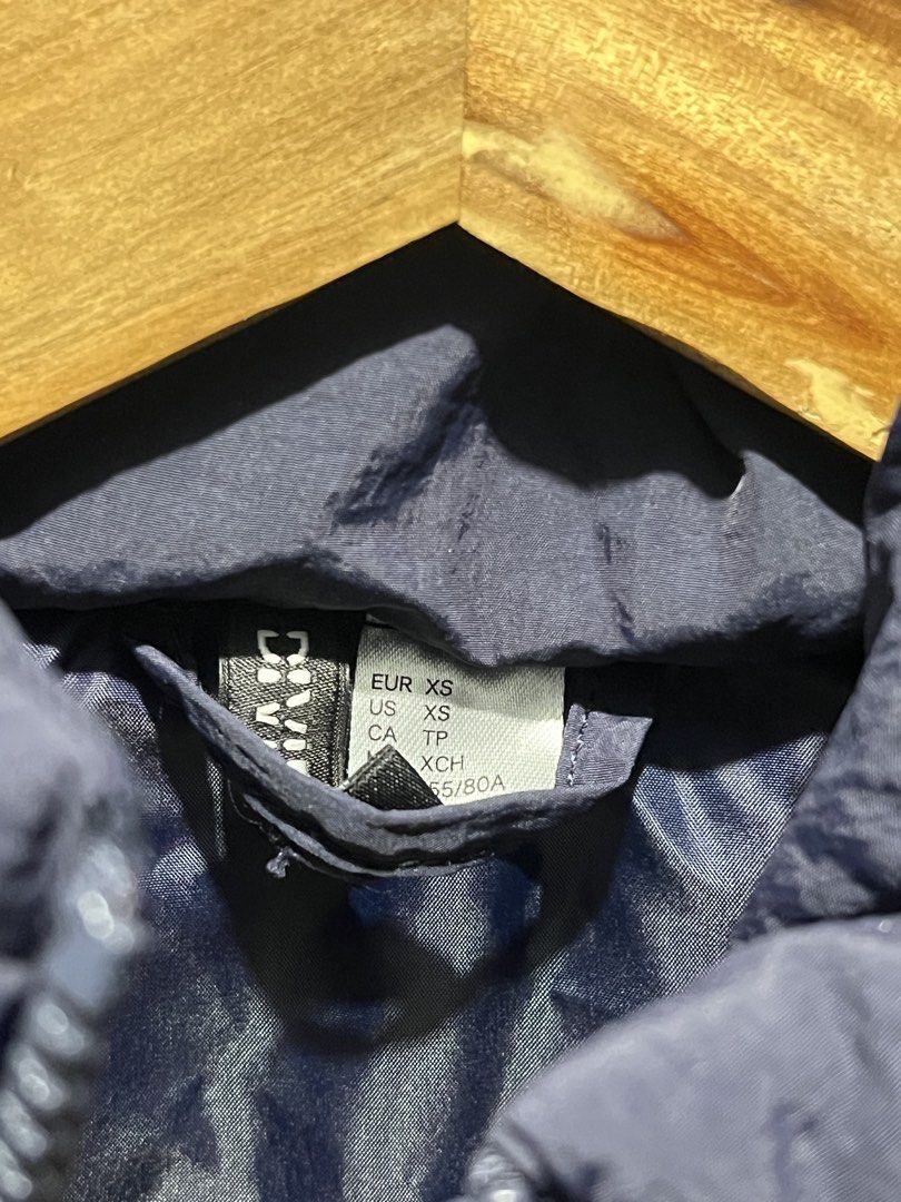 DIVIDED Navy Puffer Vest Size XS (Category: Sleeveless) located in Manila. Submitted by bosetph (Listing ID 1466570790, Image 3). Description: - Brand: DIVIDED - Size: XS - Color: Navy blue - Design: Quilted with synthetic padding and high stand collar - Closure: Full front zipper - Condition: Clean, no obvious flaws - Perfect for layering with hoodies, sweaters, or long-sleeve shirts.