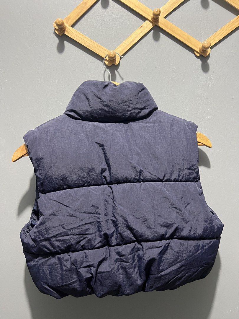 DIVIDED Navy Puffer Vest Size XS (Category: Sleeveless) located in Manila. Submitted by bosetph (Listing ID 1466570790, Image 2). Description: - Brand: DIVIDED - Size: XS - Color: Navy blue - Design: Quilted with synthetic padding and high stand collar - Closure: Full front zipper - Condition: Clean, no obvious flaws - Perfect for layering with hoodies, sweaters, or long-sleeve shirts.
