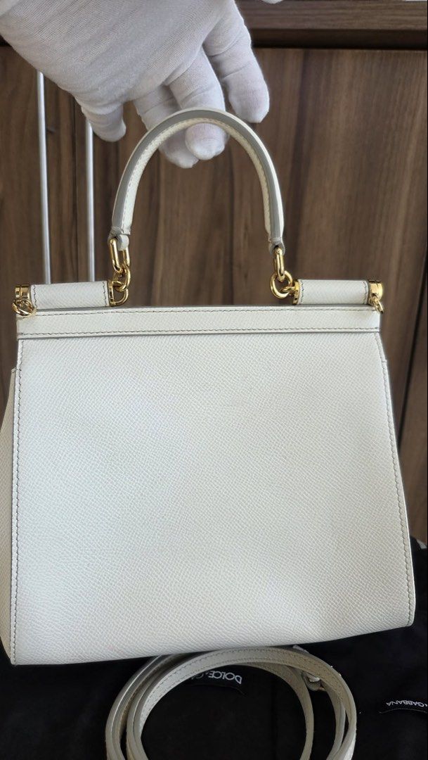 Dolce & Gabbana White Sicily Handbag (Category: Luxury Bags & Wallets) located in Rizal. Submitted by bearbricksmum (Listing ID 1466772295, Image 3). Description: White Dolce & Gabbana top handle bag. Textured leather body with gold-tone hardware and metal logo plaque on the front. Includes a detachable matching shoulder strap and dust bag. Structured shape with a single top handle and flap closure. Clean interior and exterior, ready to carry. Pi
