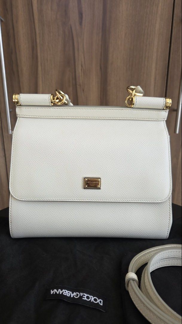 Dolce & Gabbana White Sicily Handbag (Category: Luxury Bags & Wallets) located in Rizal. Submitted by bearbricksmum (Listing ID 1466772295, Image 1). Description: White Dolce & Gabbana top handle bag. Textured leather body with gold-tone hardware and metal logo plaque on the front. Includes a detachable matching shoulder strap and dust bag. Structured shape with a single top handle and flap closure. Clean interior and exterior, ready to carry. Pi