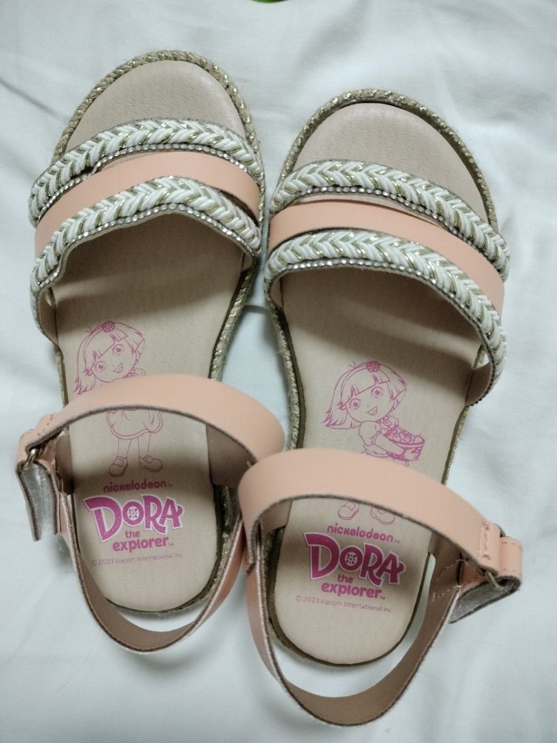 Dora the Explorer Kids Sandals Size 29 (Category: Babies & Kids Fashion) located in San Mateo. Submitted by shop_with_nicer (Listing ID 1466617917, Image 2). Description: Bought in SM at Php1250. Stocked only in the closet and never been used. - Brand: Nickelodeon Dora the Explorer - Size: 29 (marked on sole) - Color: Peach and white - Details: Braided straps with rhinestone accents, espadrille-style sole trim, and Dora graphic on insole - Closur