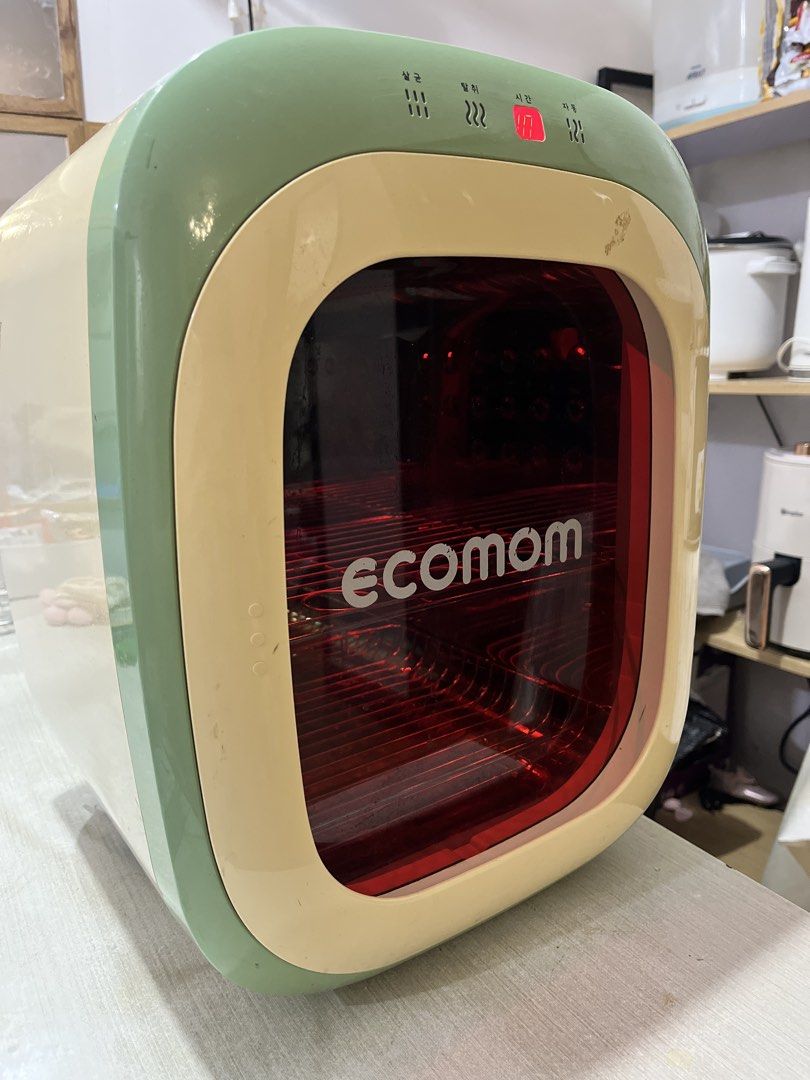 Ecomom UV LED Sterilizer Green Cream (Category: Breastfeeding & Bottle Feeding) located in Imus. Submitted by zeeeyaaahhh (Listing ID 1466709465, Image 3). Description: - Brand/Model: Ecomom Sterilizer - Color: Aesthetic Green and Cream - Interface: Top digital display with touch buttons - Design: Red tinted glass door with interior metal racks - Size: Compact countertop friendly - Condition: Powers on and displays time correctly; interior is cle