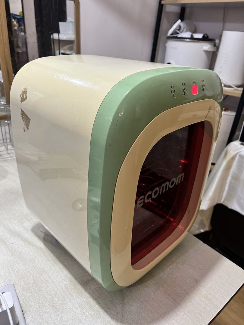 Ecomom UV LED Sterilizer Green Cream (Category: Breastfeeding & Bottle Feeding) located in Imus. Submitted by zeeeyaaahhh (Listing ID 1466709465, Image 2). Description: - Brand/Model: Ecomom Sterilizer - Color: Aesthetic Green and Cream - Interface: Top digital display with touch buttons - Design: Red tinted glass door with interior metal racks - Size: Compact countertop friendly - Condition: Powers on and displays time correctly; interior is cle