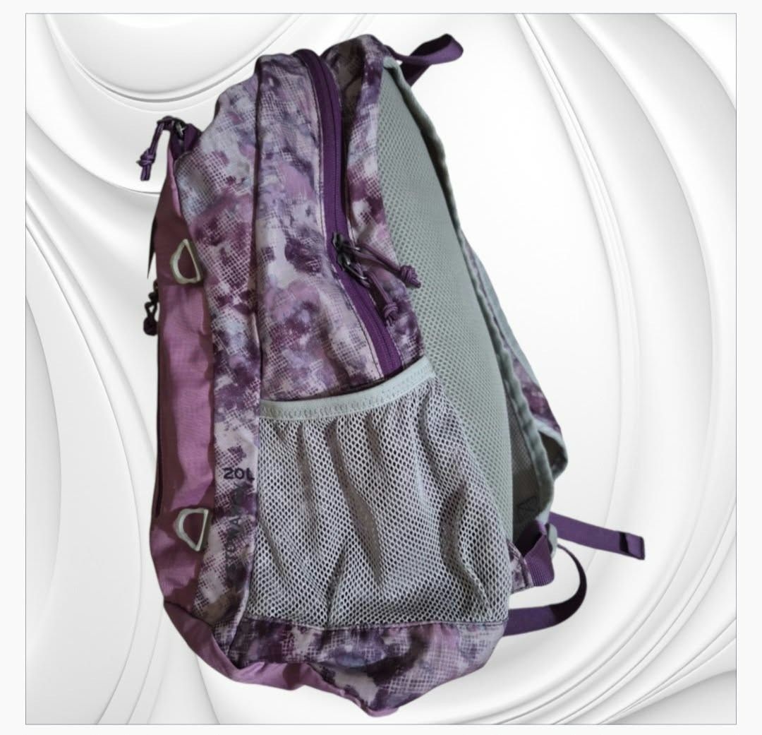 Eddie Bauer 20L Purple Pattern Backpack (Category: Backpacks) located in Paranaque City. Submitted by calm_youngstore7 (Listing ID 1466724313, Image 3). Description: - Brand: Eddie Bauer - Capacity: 20L - Design: Pink and purple patterned - Condition: Brand new with tags still attached - Compartments: Main zippered compartment, front vertical zip pocket, and mesh side pockets - Comfort: Padded mesh shoulder straps, back panel, and top grab handle