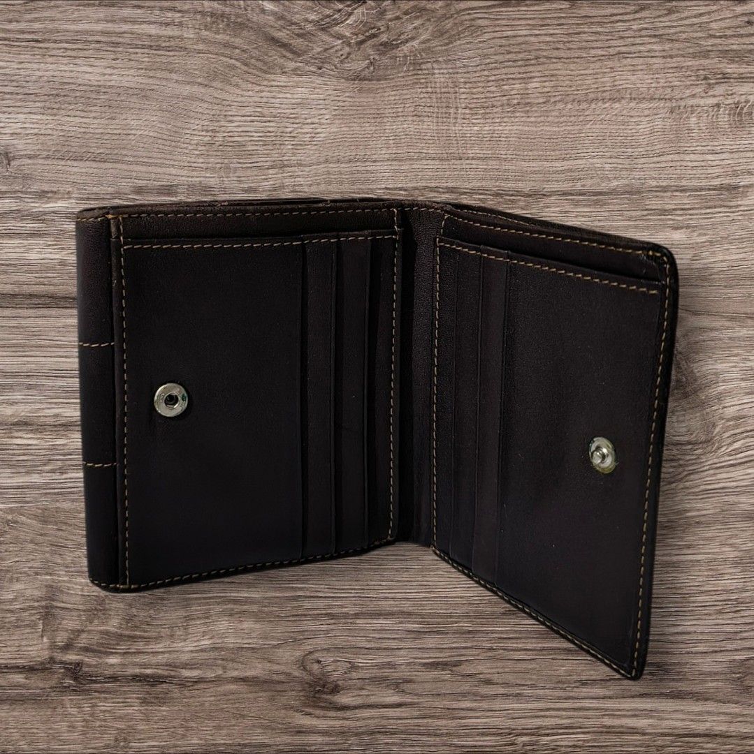Elle Paris Brown Leather Wallet (Category: Wallets & Card holders) located in Manila. Submitted by ri_ca_purse_selection (Listing ID 1466587672, Image 3). Description: - Brand: Elle Paris - Color: Dark brown leather - Design: Contrast stitching and stamped front logo - Closure: Secure snap button - Storage: Multiple card slots and spacious bill compartments - Style: Classic folded, compact size that easily fits in a bag or pocket.